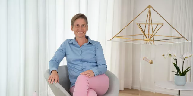 Irène Schärli sitzt auf einem Sessel in Ihrem Büro/Studio